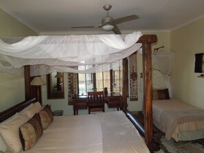 Una camera da letto con un letto a baldacchino, una scrivania e una sedia.