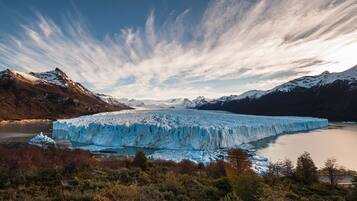 Un glaciar con vistas despejadas de las montañas circundantes y una masa de agua.