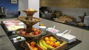 Un buffet proposant une variété d’aliments, notamment des fruits et du pain, disposés sur un comptoir.