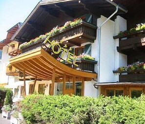 Een hotel met een houten balkon en bloembakken.