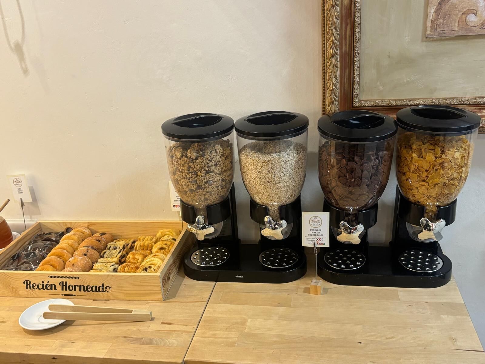 A breakfast buffet with various cereals and pastries.