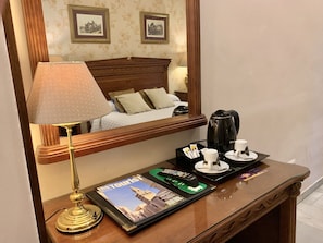 A hotel room with a bed, a nightstand with a lamp, a coffee maker, and a magazine on the nightstand. - Hotel Europa (Seville)