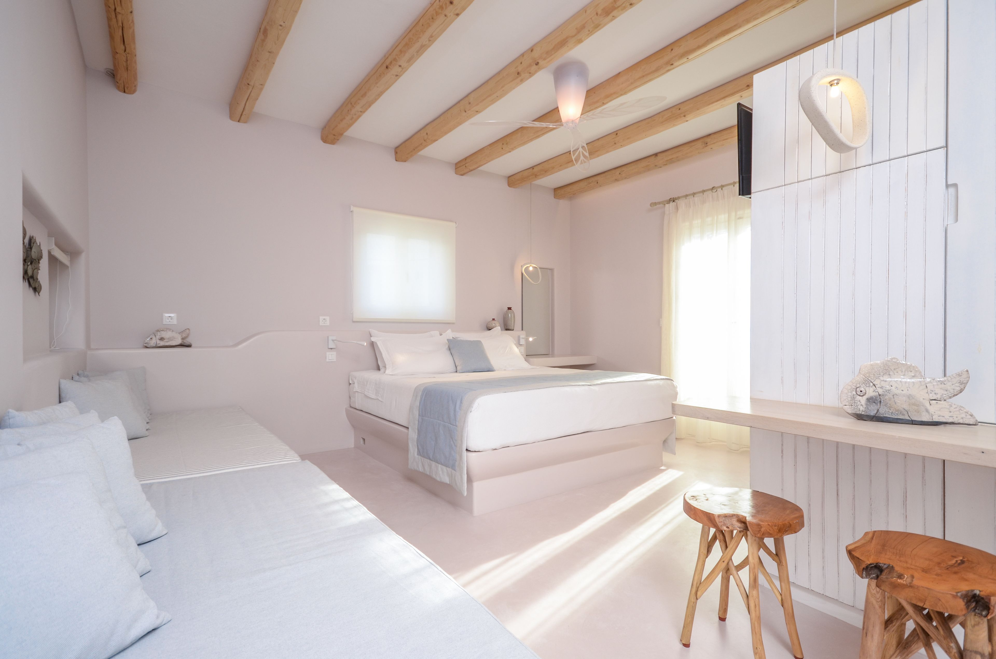 Une chambre à coucher avec un lit, une table de chevet et un tabouret en bois.