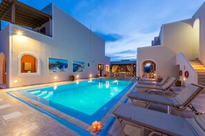Una piscina al aire libre, sombrillas, tumbonas