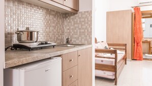 A modern kitchen with wooden cabinets, a built-in stove, and a tiled backsplash. - Villa Voula (Santorini)
