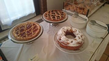 A buffet table with various pies and pastries.