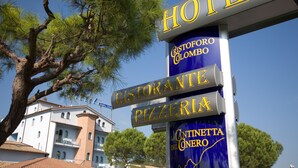 Señal que indica la presencia de un hotel, restaurante y pizzería cerca.