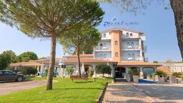 Hotel Giustino Colombo offers a Mediterranean-style entrance with arched windows and a balcony above.