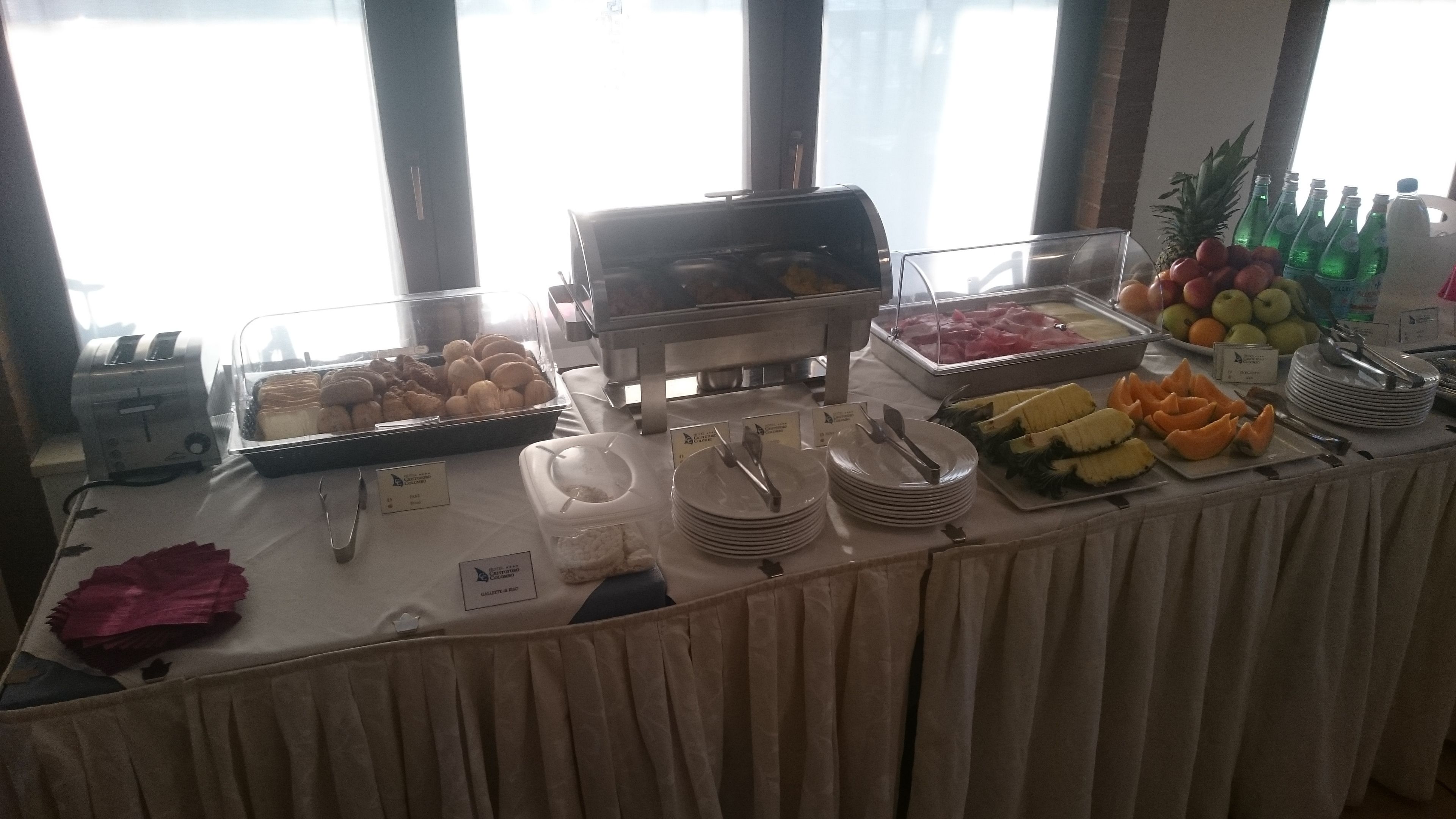 A buffet table with various food items and utensils.