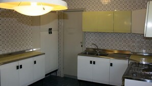 A kitchen with white cabinets, a stainless steel sink, and a gas stove. - L'Aura di Sicilia (Ragusa)