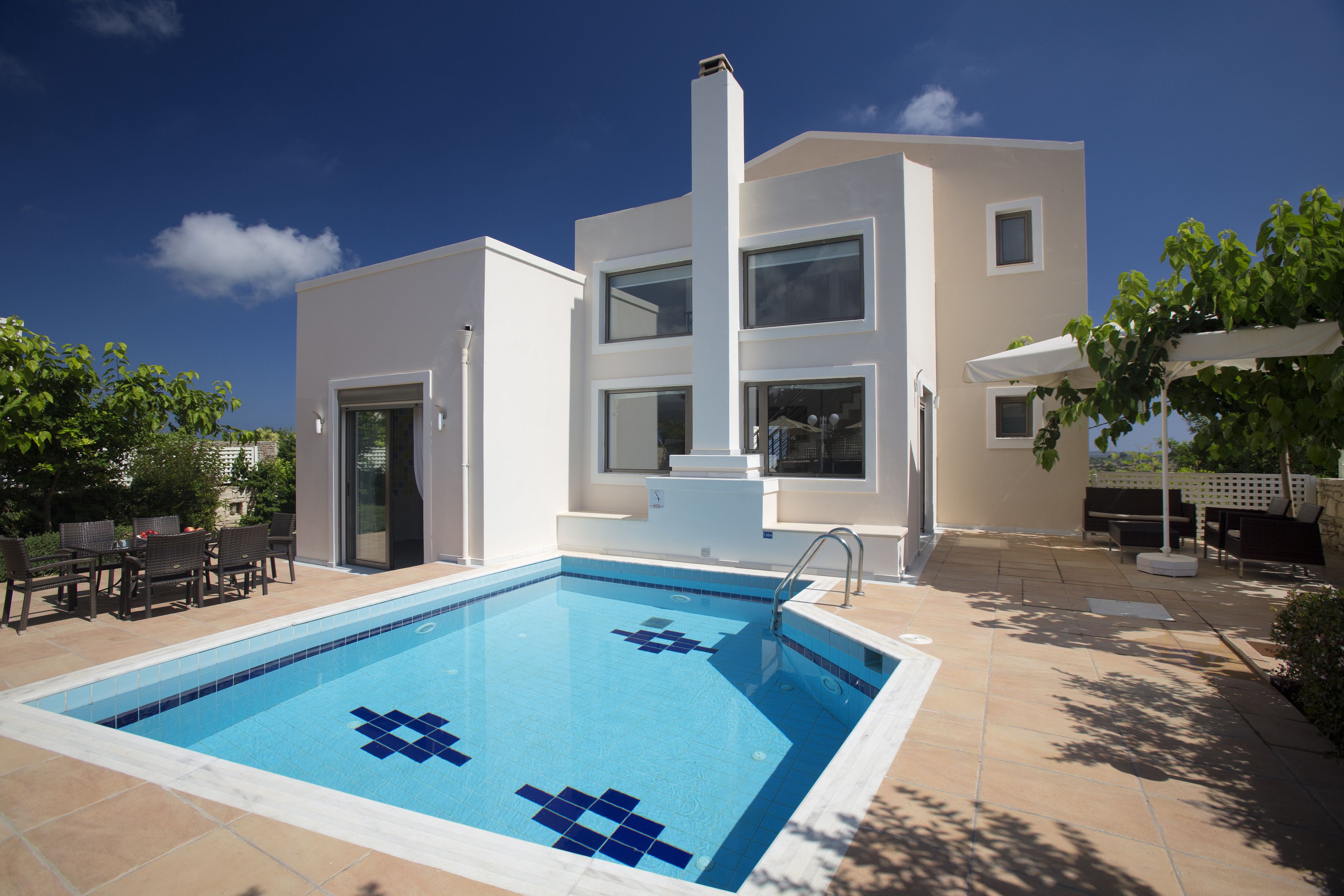 A modern two-story building with a swimming pool in the foreground.