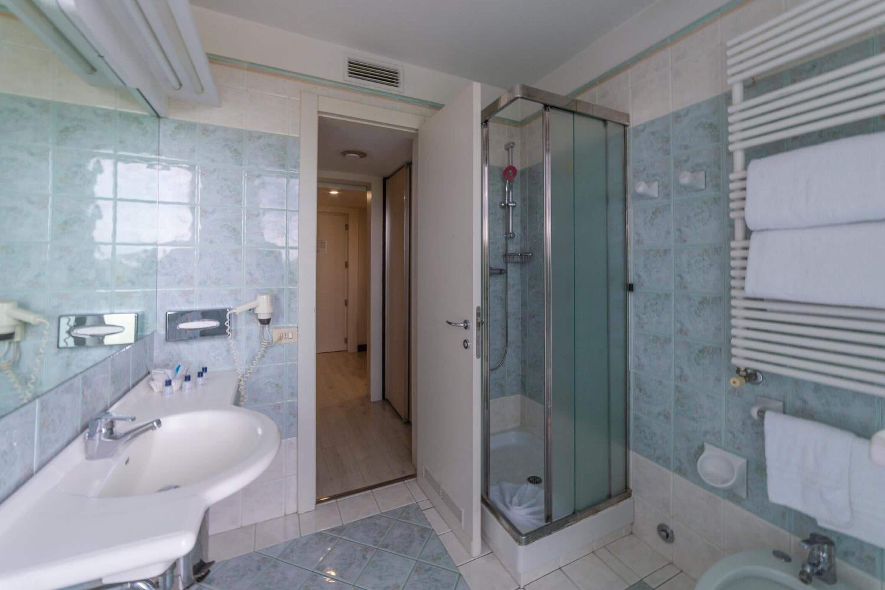 Une salle de bain avec une douche à parois de verre, un lavabo et des toilettes.