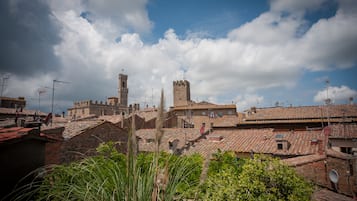 Un pueblo histórico con arquitectura tradicional, incluyendo una torre destacada y varios edificios con tejados de tejas.