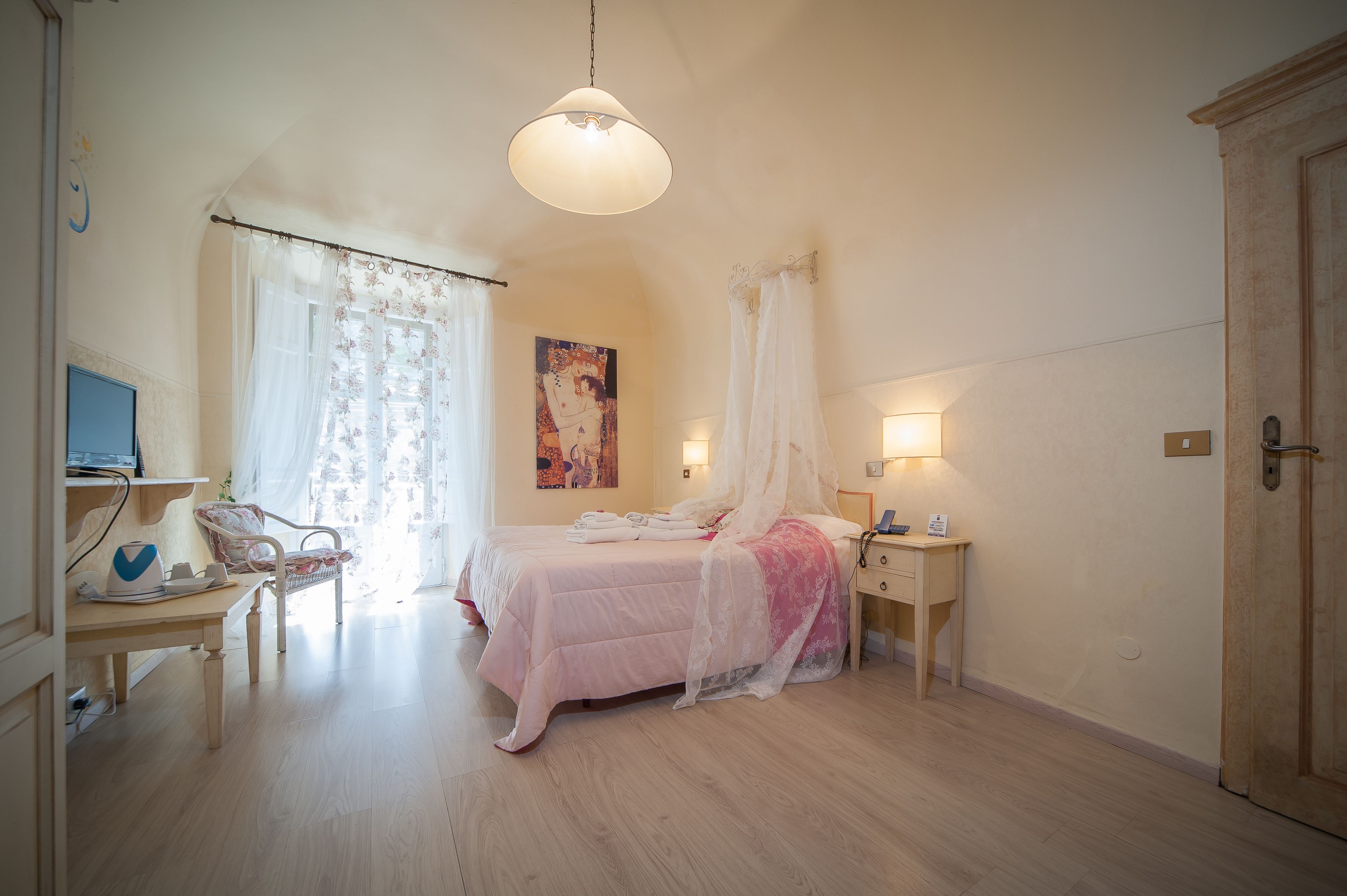 A bedroom with a bed, a desk, a chair, a bedside table, and a wardrobe.