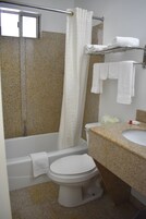 Un baño con bañera, inodoro y lavabo.