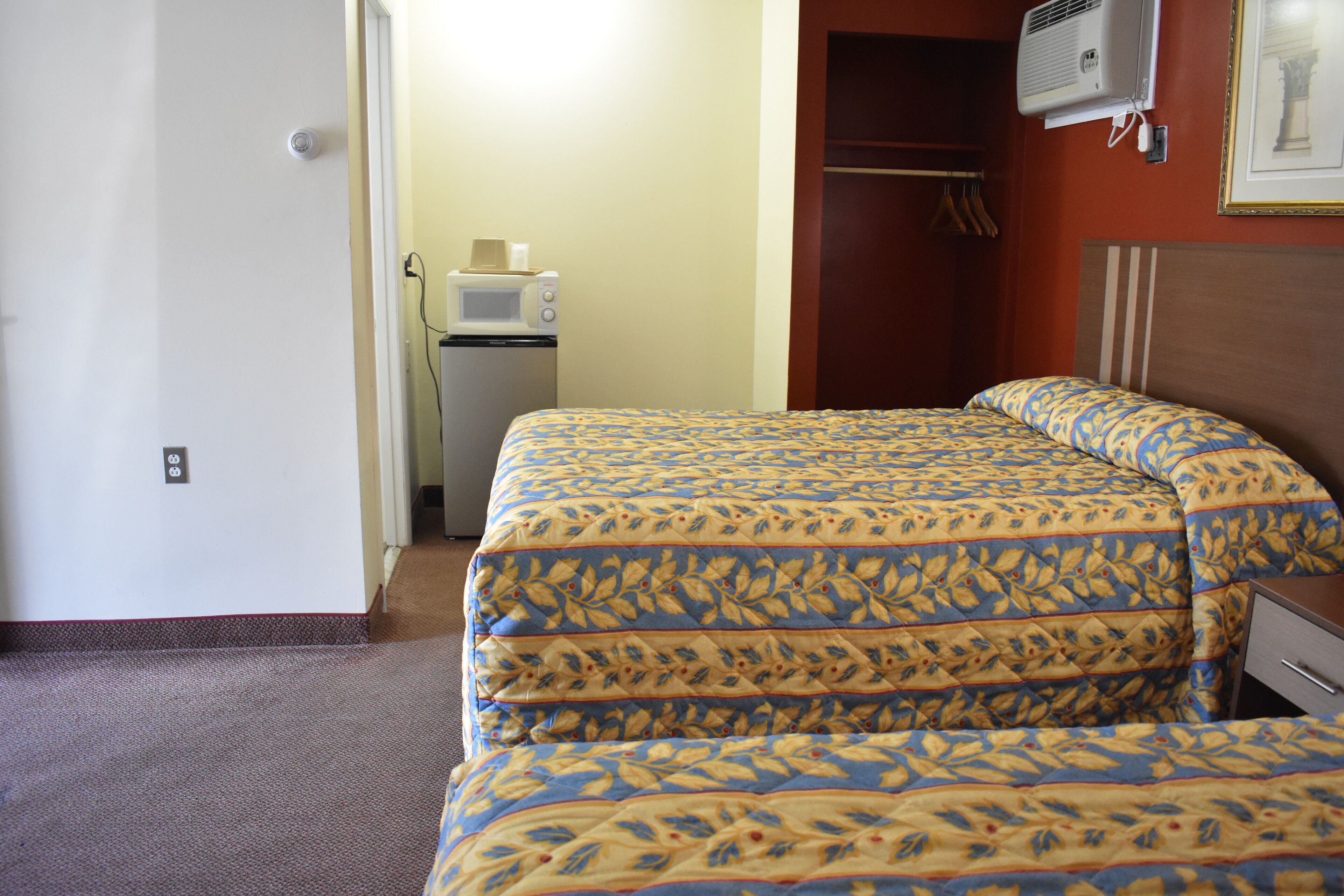 Habitación de hotel con cama, microondas y armario.