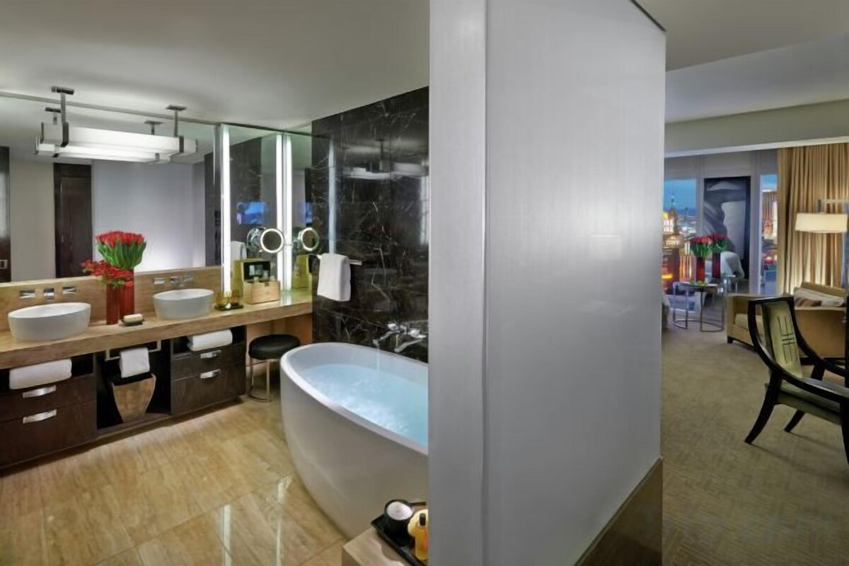 Une salle de bain moderne dotée d’une grande baignoire, de deux lavabos et d’un meuble-lavabo avec un miroir.