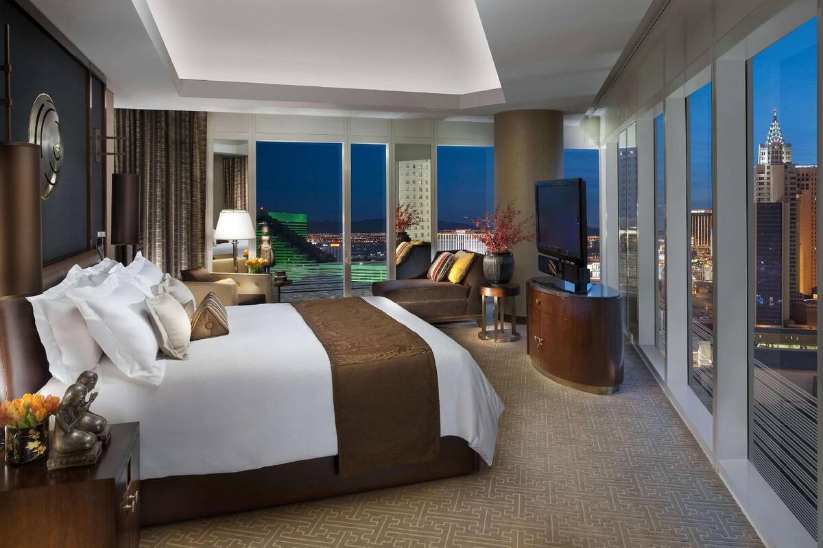 Une chambre d’hôtel avec un grand lit, un bureau, une télévision et une vue sur la ville.