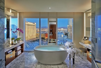 A hotel room with two beds, a view of the cityscape, and a decorative wall panel. at Waldorf Astoria Las Vegas