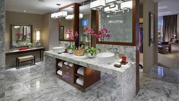 A modern bathroom with two sinks, marble flooring, and large mirrors.