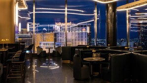 A modern interior with a view of the Hollywood sign, featuring sleek furniture and ambient lighting.
