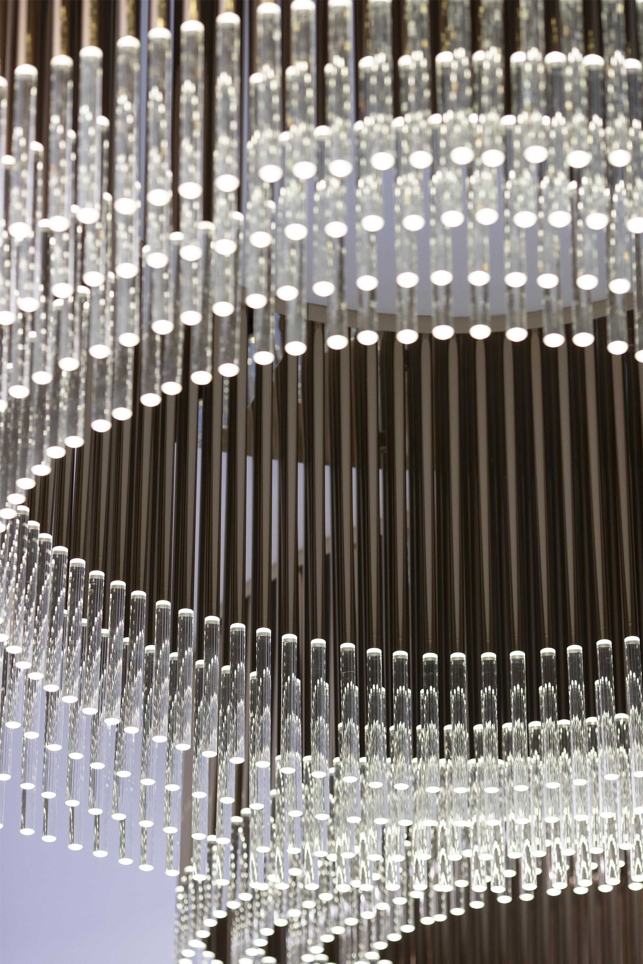 A close-up of a modern, reflective, metallic structure with cylindrical elements and circular lights.