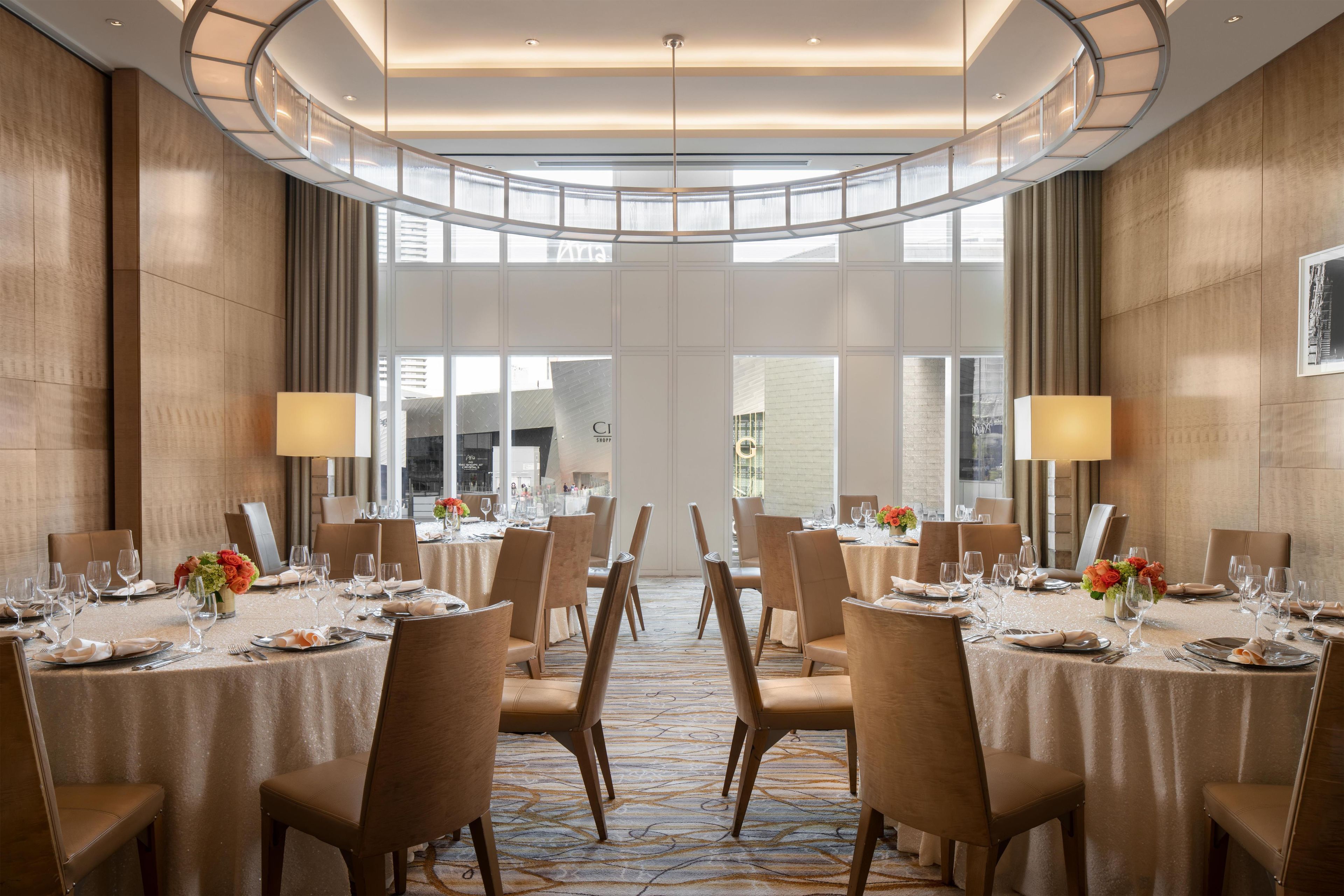 A conference room with round tables, chairs, and a large window.
