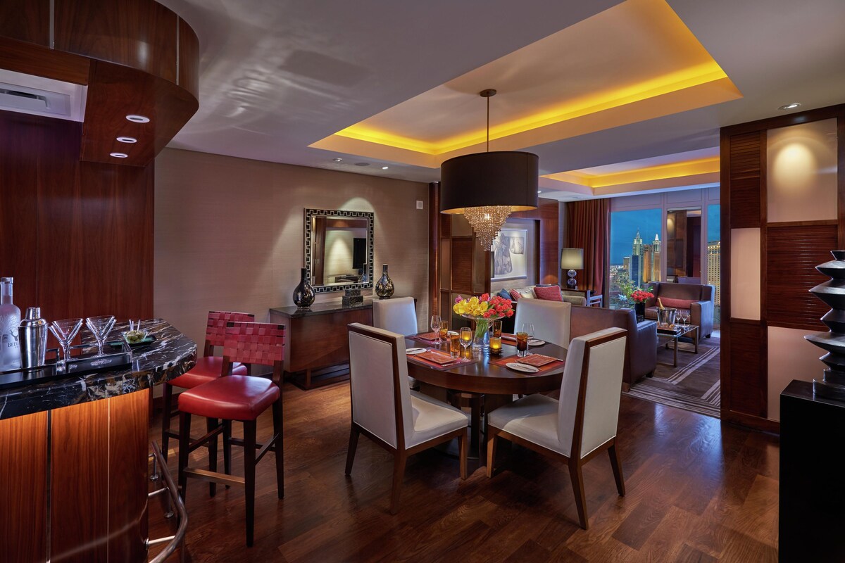 Een moderne hotellobby met een bar, een eetgedeelte en uitzicht op de stadshemel.