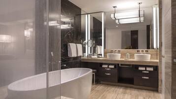 A modern bathroom with a freestanding bathtub, a vanity with two sinks, and a large mirror.