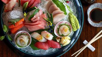 Een sushi schotel met diverse soorten vis en garneringen op ijs.