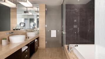 Une salle de bain moderne avec deux lavabos, un grand miroir et une douche à l’italienne.