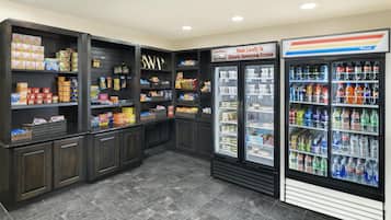 A grocery store with shelves stocked with snacks, beverages, and refrigerated sections.