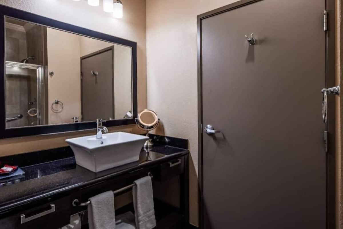 A bathroom with a sink, mirror, and towel rack.