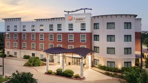 A hotel with a prominent 'Premier Best Western' sign, multiple floors, and a covered entrance area. - Best Western Premier Crown Chase Inn & Suites (Denton)