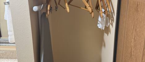 A laundry area with an iron, wooden hangers, and a drying rack.