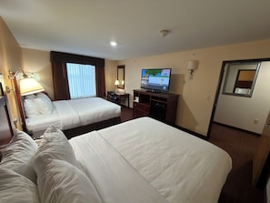 A hotel room with two beds, a desk, a television, and a mirror. - Americas Best Value Inn St. Robert (St. Robert)