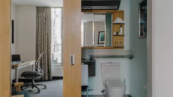 Een hotelkamer met een bureau, stoel en toilet.