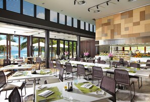 A spacious dining area with multiple tables and chairs, large windows offering views of the ocean, and a modern interior design. - InterContinental Sanya Resort by IHG (Sanya)