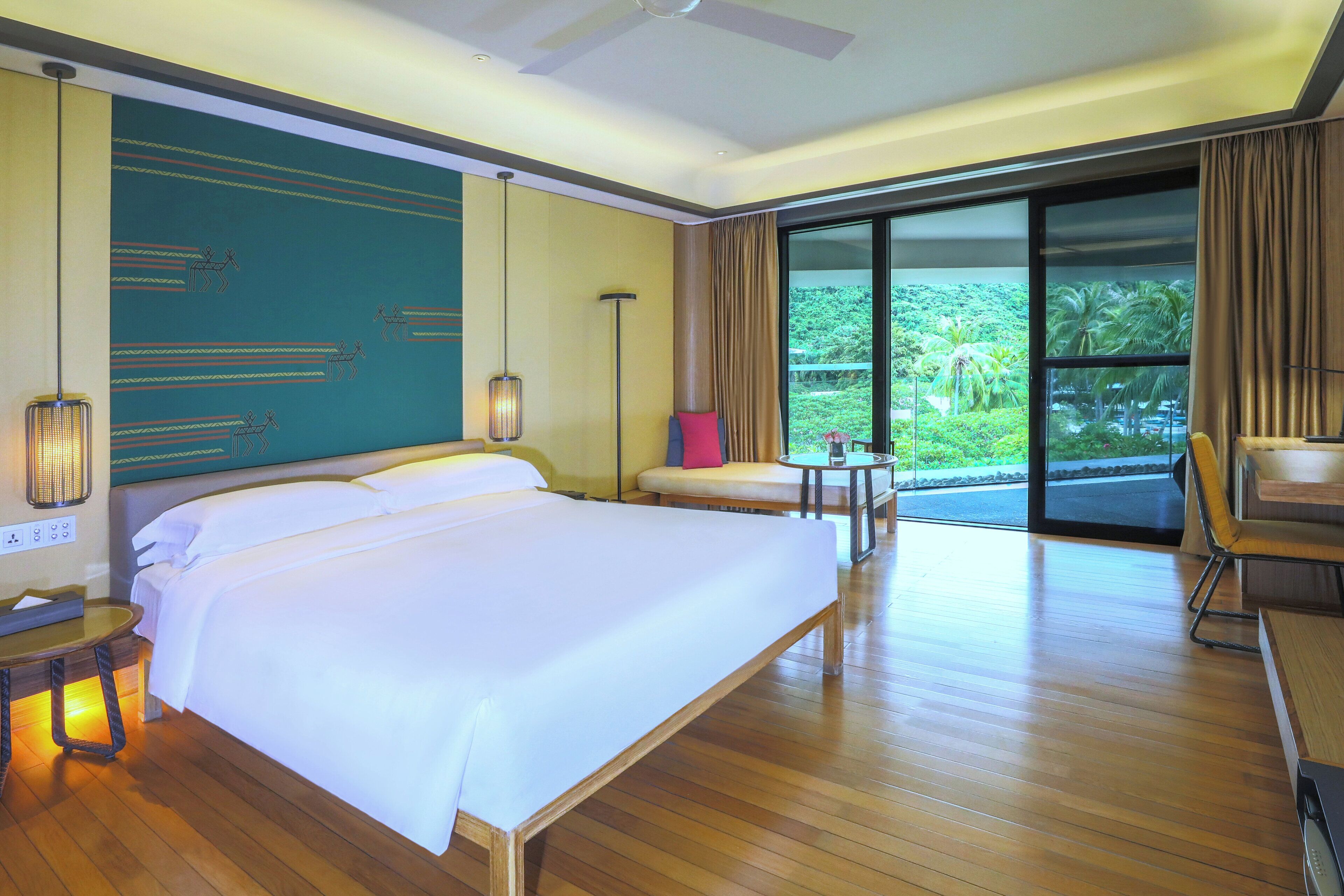 Une chambre d’hôtel avec un grand lit, un bureau, une chaise, une table et une vue sur l’extérieur.