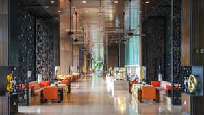 En rymlig hotellobby med en lång korridor, sittgrupper och en receptionsdisk.
