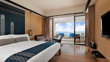 Habitación de hotel con una cama grande, una mesita, una silla y un televisor.