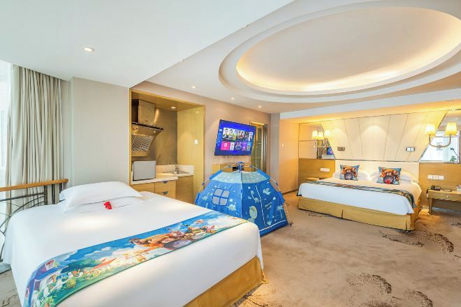 Habitación de hotel con dos camas, un televisor, una tienda de campaña y un techo con diseño circular.