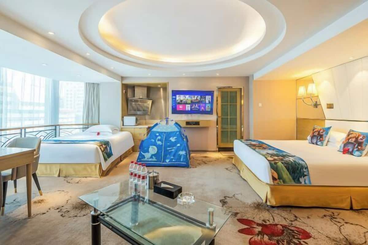 A hotel room with two beds, a TV, a desk, a glass coffee table, and a view of the city.
