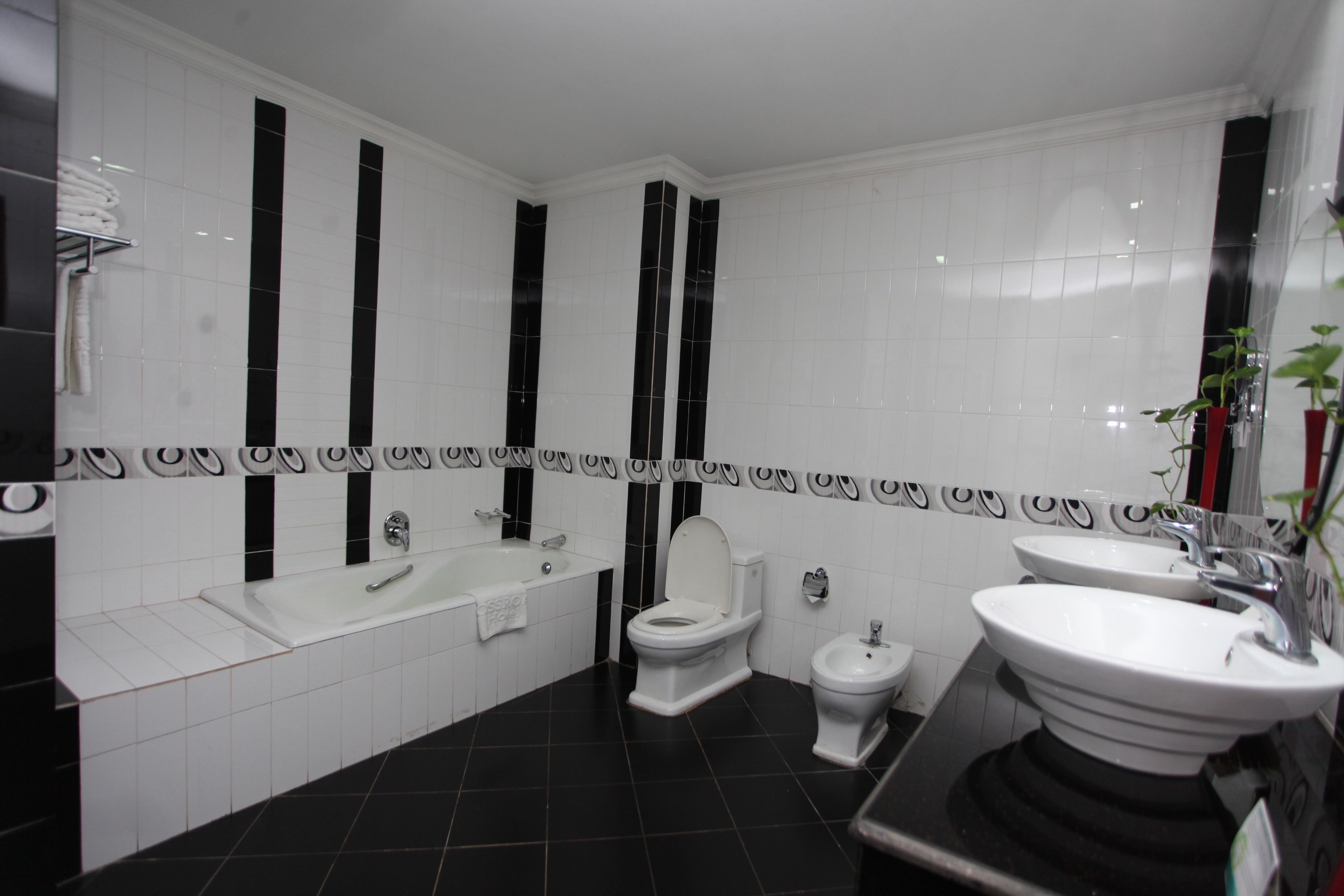 Ein modernes Badezimmer mit Badewanne, Toilette und zwei Waschbecken.