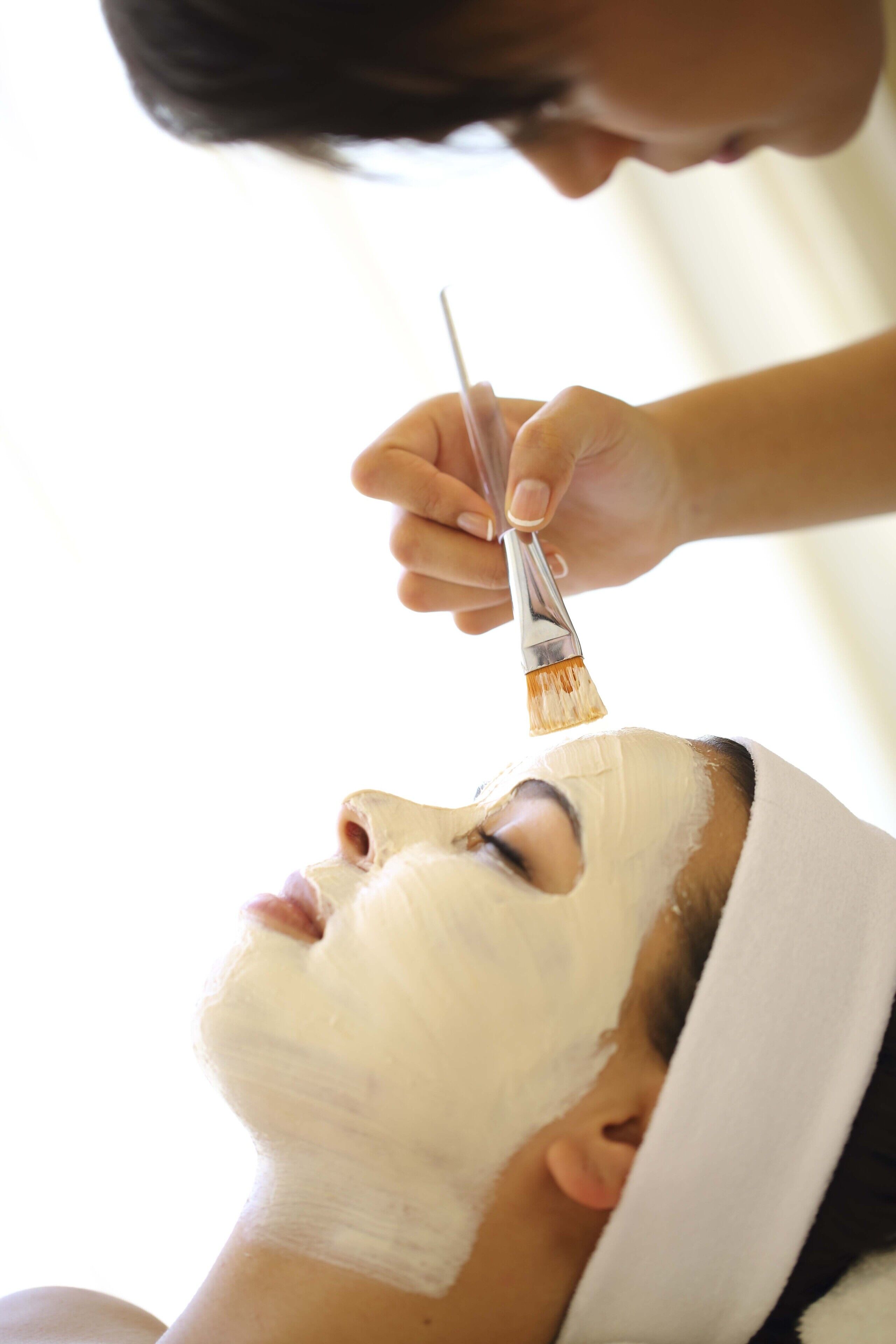 Una persona recibiendo un tratamiento facial con un cepillo.