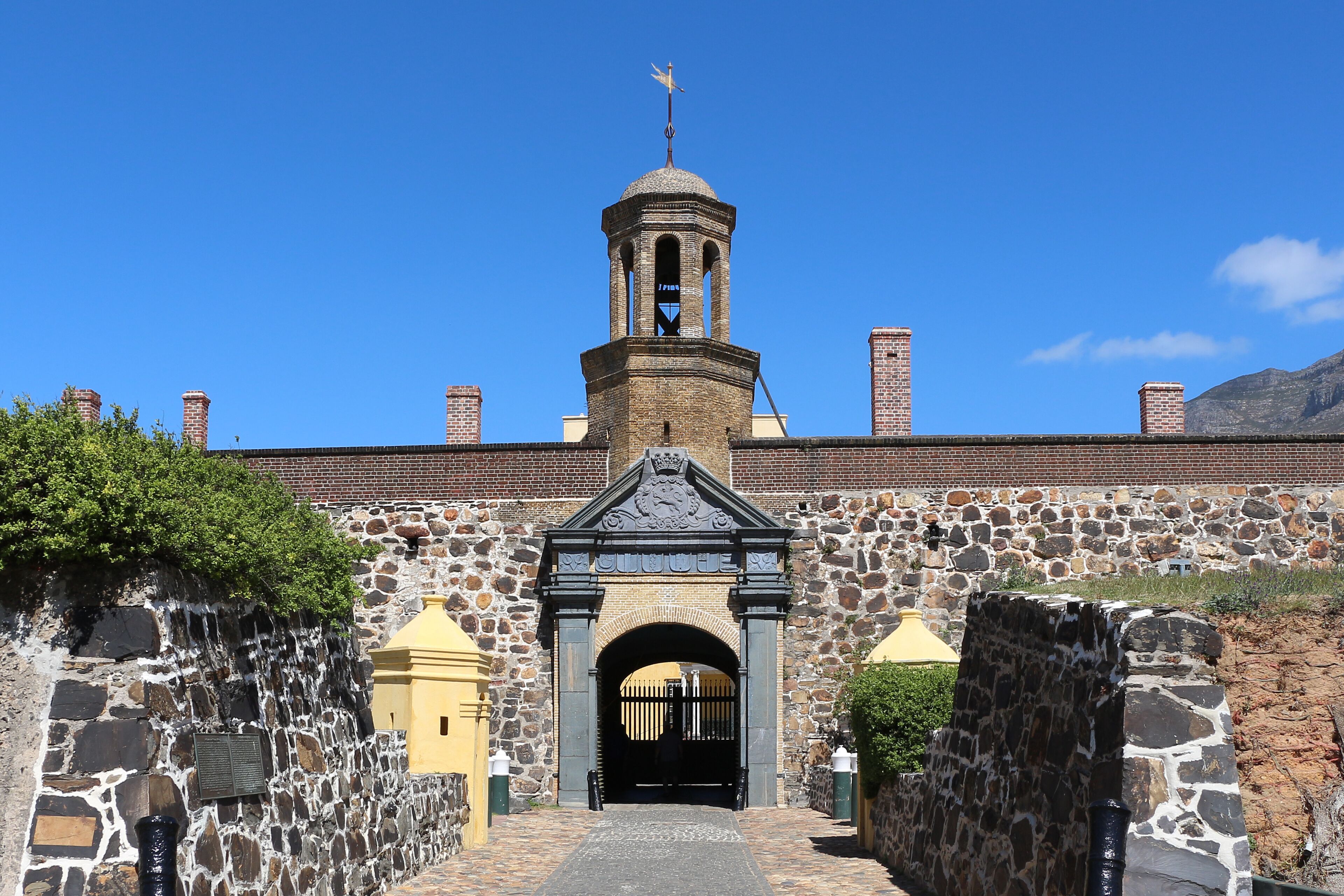Un bâtiment historique doté d’une tour centrale, de murs en pierre et d’une entrée en arc de cercle.