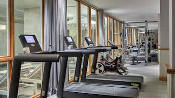 Un gimnasio de hotel con cintas de correr, una bicicleta estática y máquinas de pesas.