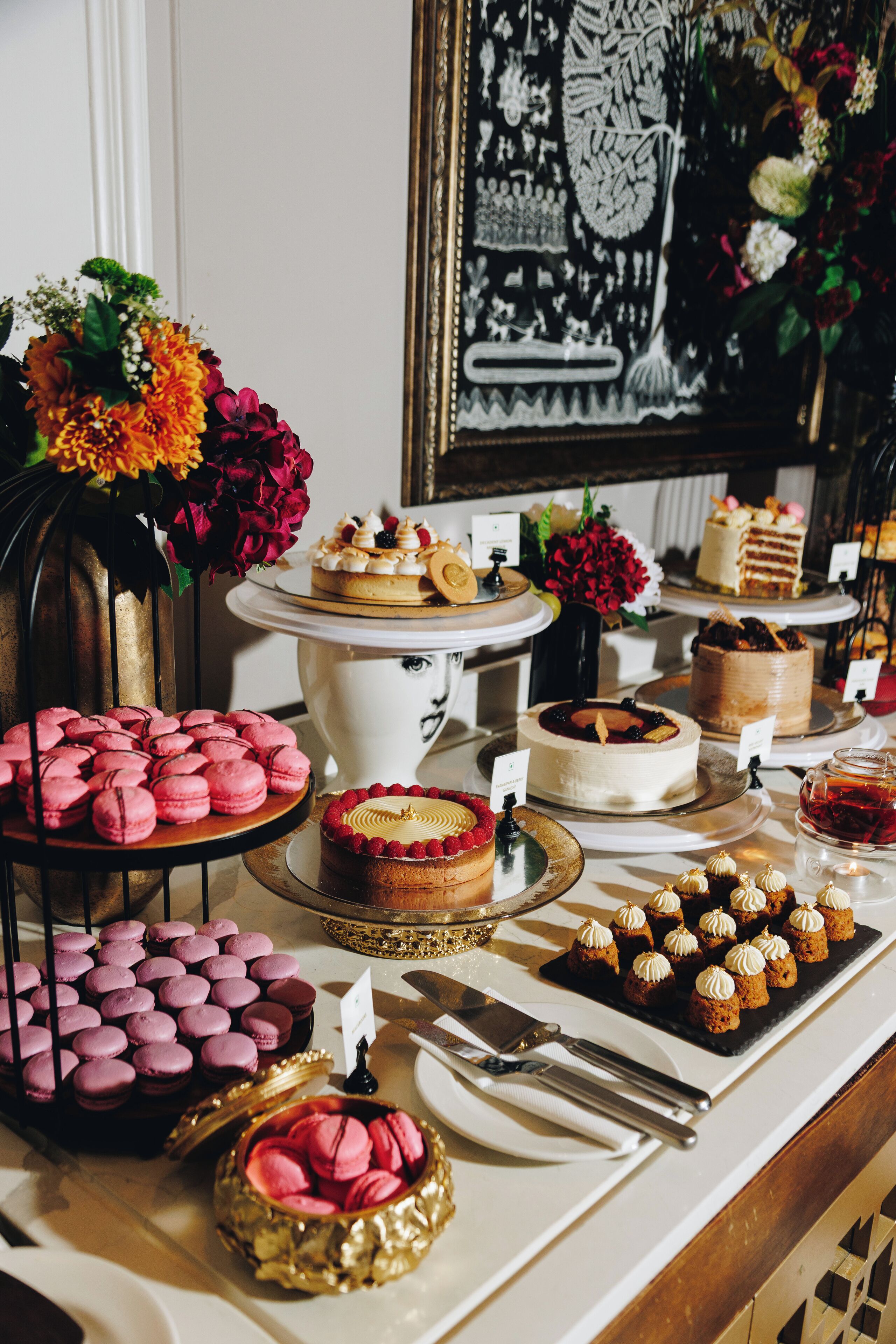 A dessert table with various cakes, macarons, and pastries.