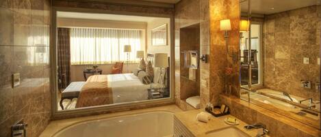 A modern bathroom with a large bathtub, a glass-enclosed shower, and a vanity with a mirror.