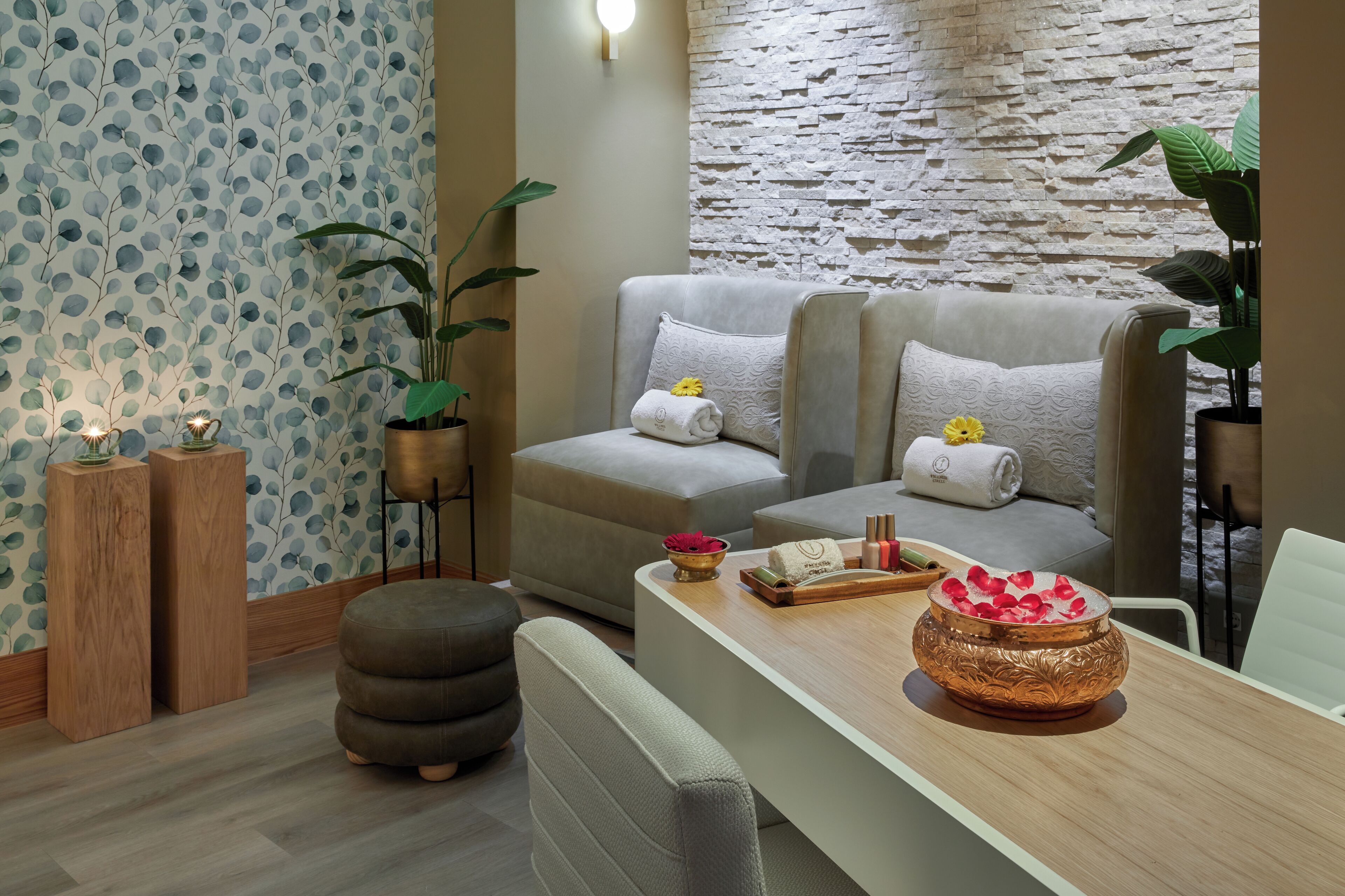 Una sala de estar moderna con un sofá, un reposapiés y una mesa de centro de madera con adornos.
